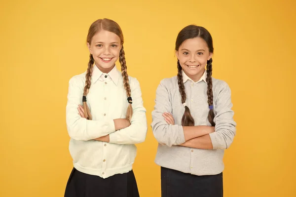 Estudiar juntos es divertido. niñas inteligentes sobre fondo amarillo. Día del conocimiento. Feliz infancia. Moda infantil. Amistad y hermandad. concepto de educación. de vuelta a la escuela. niñas en uniforme escolar —  Fotos de Stock