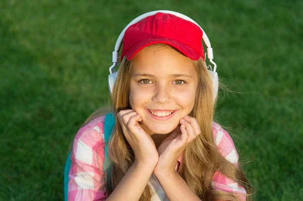 Alles ist cool. Cooles Kind hört Musik auf grünem Gras. Glückliche Kinder benutzen Kopfhörer im Freien. Coole Entspannungsmusik. Beruhigende Melodien. Neue Technologie zum Vergnügen. Mode und Stil. Kühl und modern — Stockfoto