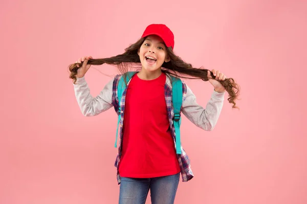 Η κομμώτρια της. Ευτυχισμένο κορίτσι κρατήσει μακριά μαλλιά ροζ φόντο. Παιδικό κομμωτήριο. Κομμωτήριο για παιδιά. Μαγαζί ομορφιάς. Στυλ μαλλιά με κομμωτήριο. Χαρίστε στον εαυτό σας μεγάλη υπηρεσία — Φωτογραφία Αρχείου