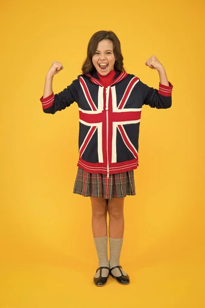 Learn english language. British accent. Great Britain flag. International exchange. Girl school uniform. English student. Education and upbringing. Language school. English kid yellow background