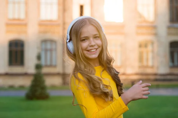 Odległe uczenie się. Słuchanie dobrych historii. Samokształcenie. Słuchawki z technologią bezprzewodową. Małe dziecko słuchające muzyki współczesne słuchawki. Szczęśliwa dziewczynka w słuchawkach. Dźwięk stereo — Zdjęcie stockowe
