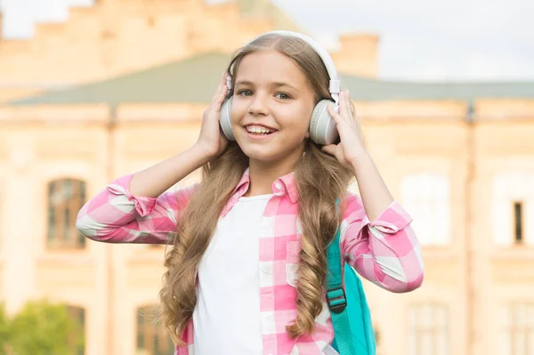 Podcast educativo. A la niña le gusta la música. Es un buen momento. Los auriculares infantiles escuchan música. Concepto de audio libro. Estudiando lecciones de audio. Escucha música mientras caminas. Auriculares para chicas escuchando música — Foto de Stock