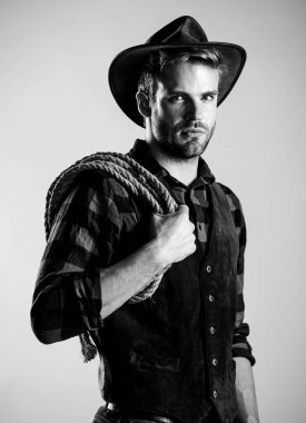 Gerçek bir erkek. Klasik tarz adam. Vahşi Batı eski kovboy. Kement ipli bir kovboy. Batı. Vahşi batı rodeosu. Şapkalı adam. Çiftlikte kareli gömlek. Batı kovboy portresi