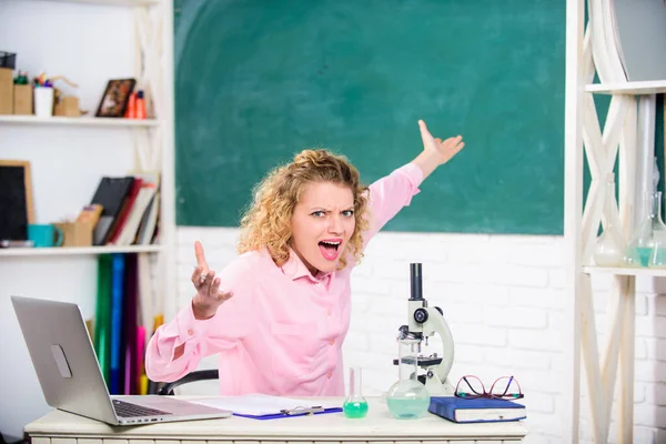 Emotionele controle. Emotionele mensen concept. Emotionele vrouwelijke leraar opvoeder in de klas schoolbord achtergrond. Vrouw tutor of student aan het bureau met laptop en schoolbenodigdheden briefpapier — Stockfoto