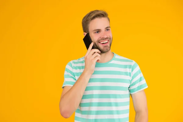 Важливість комунікації. Щасливий чоловік говорить на жовтому фоні мобільного телефону. Вербальне спілкування. Мобільний зв'язок. Телефонний зв'язок. Технології зв'язку. Сучасне життя — стокове фото