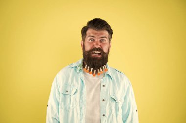 Adam sakallı mandal. Kalpleri mandallı vahşi bir hippi. Sakallı adam sıradan sarı arka plan. Sevgililer Günü. Kuaförde saç kurutma. erkek için bireysel saç şekli