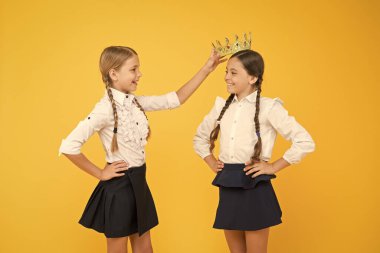 Taç ona yakışıyor. Sevimli küçük bir çocuk, küçük şampiyon kızı tacıyla ödüllendiriyor. Mutlu küçük kazananlar ve şampiyon taç giyme töreni. Şampiyon tacını taktı. Okul yarışmaları konsepti. Kraliyet dostluğu