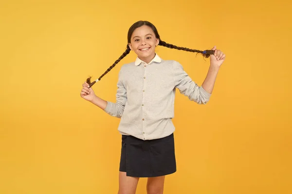 Χαρούμενο βλέμμα. έξυπνο κοριτσάκι σε κίτρινο φόντο. ημέρα της γνώσης. Παιδική ευτυχία. ευτυχισμένο κορίτσι με σχολική στολή. Παιδική μόδα. σχολικής αγοράς. της εκπαιδευτικής ιδέας. πίσω στο σχολείο — Φωτογραφία Αρχείου