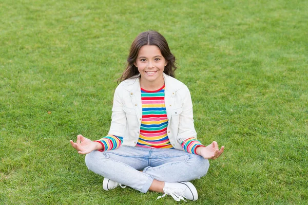 Peace of mind. School break for rest. Adorable pupil. Girl kid sit on lawn. Girl school uniform enjoy relax. Importance of relaxation. Little schoolgirl. Relax at school yard. Kid relaxing outdoors