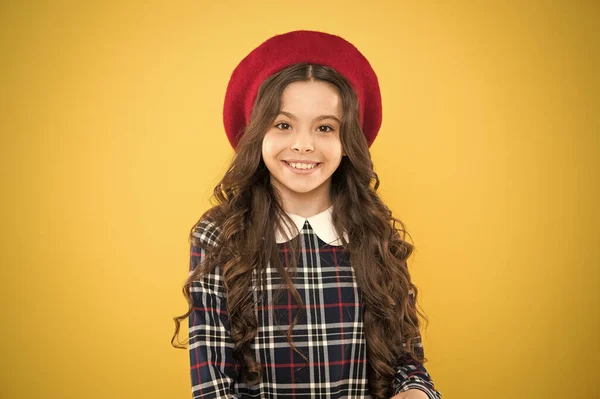 Buen humor. uniforme escolar de moda. Moda infantil. niño sobre fondo amarillo. Chica de la moda parisina. Día de los niños. chica feliz en boina francesa. niña pequeña con el pelo rizado largo —  Fotos de Stock