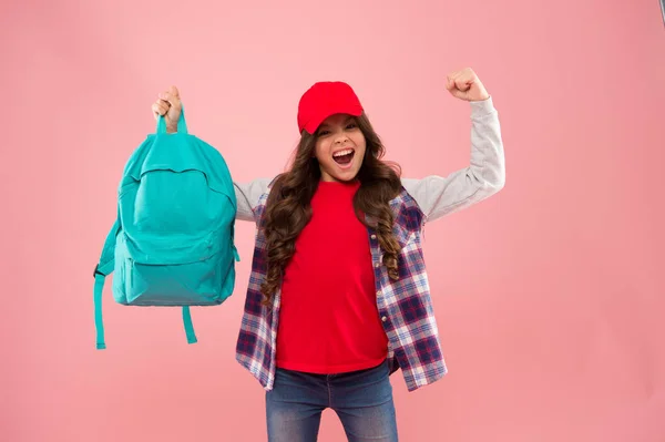 Winner gives what it takes. Happy winner hold school bag pink background. School contest winner. Happy girl make winner gesture. Celebrating victory or success. Supreme champion. Knowledge is power