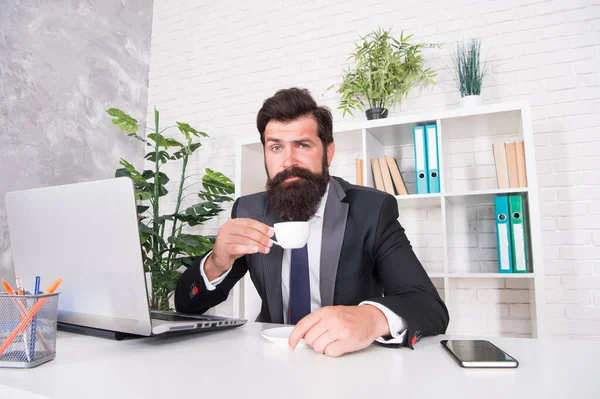 谁不喜欢早上喝热饮。工程师把茶杯放在工作台上.长胡子的男人喜欢喝咖啡。喝热饮以获取能量。健康的饮酒习惯。早上和早餐 — 图库照片