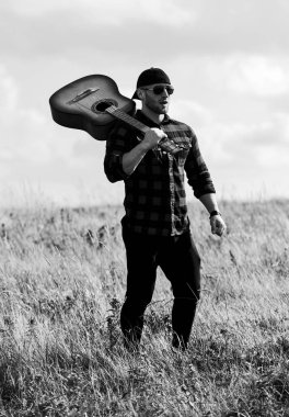 Doğayla bütünleşti. Yaz tatili. Hayalperest gezgin. Huzurlu bir ruh hali. Yürüyüş şarkısı. İlham arayan bir müzisyen. İlham verici bir doğa. Gitar çalan yakışıklı bir adam doğayı düşünüyor. İlham perisi ararken