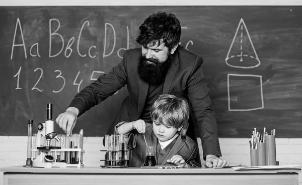 student doing science experiments with microscope in lab. father and son at school. using microscope in lab. Back to school. man with little boy. school lab equipment. Develop an energy to learn.