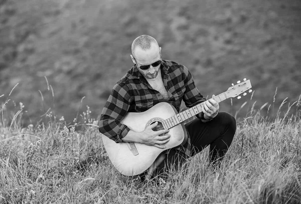 Man with guitar on top of mountain. Acoustic music. Music for soul. Playing music. Sound of freedom. Musician hiker find inspiration in mountains. In unison with nature. Keep calm and play guitar