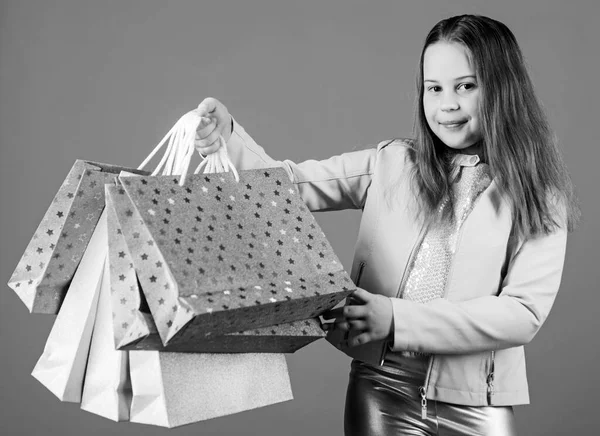 Ahorro de compra vacaciones. Ventas y descuentos. Moda infantil. asistente de tienda con paquete. Niña pequeña con bolsas de compras. Feliz niña. Niña con regalos. Compras navideñas. regalos de shristmas —  Fotos de Stock