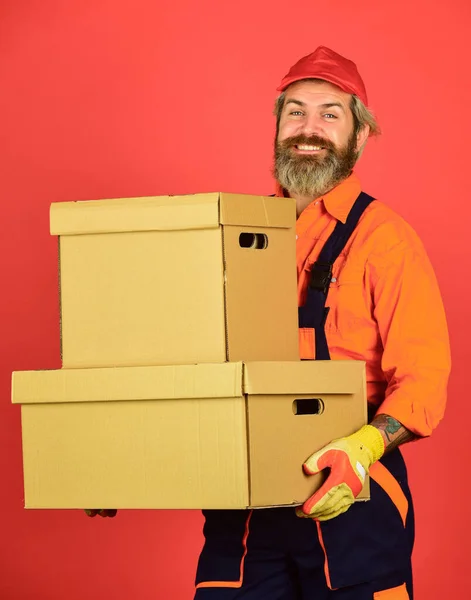 New home. Unpacking moving boxes. Moving day. Bearded man courier hold boxes. Moving to new apartment. Post service. Bearded loader in uniform. Renovation preparation. Bearded hipster indoors — Stock Photo, Image