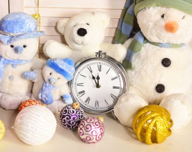 Kardan adam, oyuncak ayı ve Noel ağacı topları çalar saatin yanında.