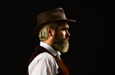 Olgun kovboy. Dedektif onayı ya da selamlaması. Trilby şapkası. Eski tarz geniş kenarlı şapkalı bir adam. Retro şapkalı adam. Takım elbiseli vahşi sakallı hippi. Mafya Erkekler Kulübü