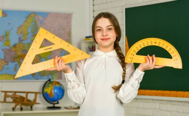 Geometri favori konusu. Açıları derece cinsinden ölçün. Küçük kız geometri dersi için açıölçer ve üçgen kullanıyor. Alet kullanmayı öğren. Okula dönüyorum. Lise öğrencisi sınıfta geometri öğreniyor