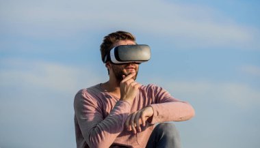 Yenilikçi teknolojilerle çalışmak. Kendi işini kur. Dijital gelecek ve yenilik. Seksi adam gökyüzü arkaplan gözlüğü. Erkek gerçekliği. Çok modern görünüyorsun. Maço adam kablosuz VR gözlük takıyor..