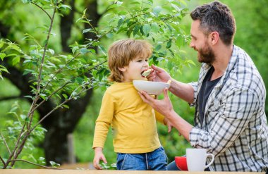 Aile ve ebeveynlik. Babalar günün kutlu olsun. Babasıyla küçük çocuk mısır gevreği yiyor. Sabah kahvaltısı. Sağlıklı yemek ve diyet. Süt ürünleri. Baba ve oğul dışarıda yemek yiyorlar. Diyet kimin umurunda?