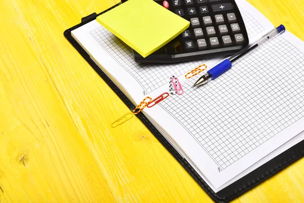 Calcolatrice, taccuino, graffette, penna e appunti adesivi, da vicino — Foto Stock
