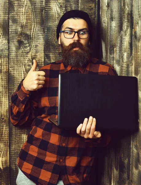 Brutalny, biały hipster trzymający laptopa — Zdjęcie stockowe
