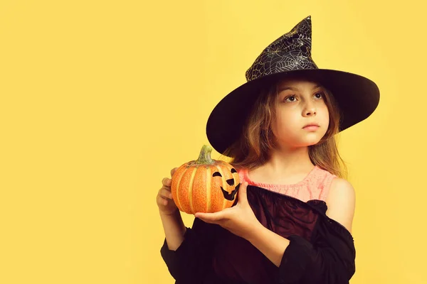 Meisje met gesneden oranje pompoen geïsoleerd op warm gele achtergrond — Stockfoto