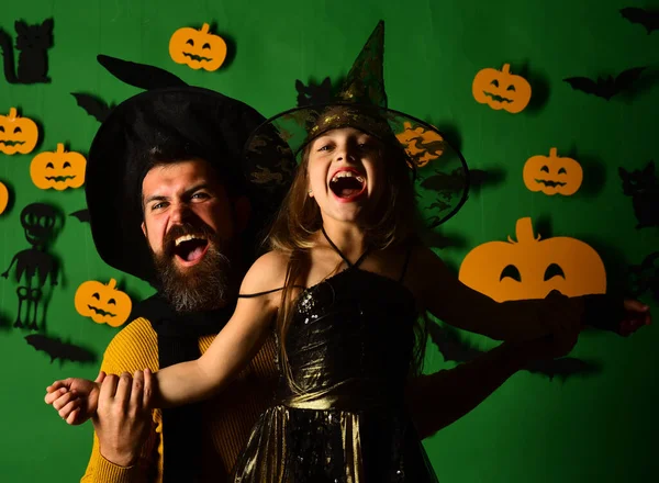 Wizard and witch in black hats. Girl and bearded man