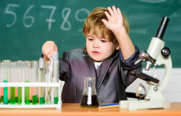 Concepto de tecnología y ciencia. Estudia biología y química en la escuela. Educación escolar. Explora moléculas biológicas. Niño genio bebé. Niño cerca del microscopio y tubos de ensayo en el aula de la escuela —  Fotos de Stock