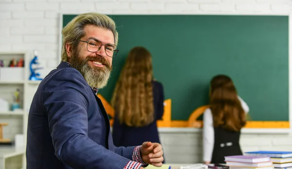 Leerling draagt uniform. Studenten die studeren en lezen. huiswerk maken schrijven en lezen. kinderen meisjes en leraar man. Basisschool leraar geeft ondersteuning in de klas. selectieve focus — Stockfoto