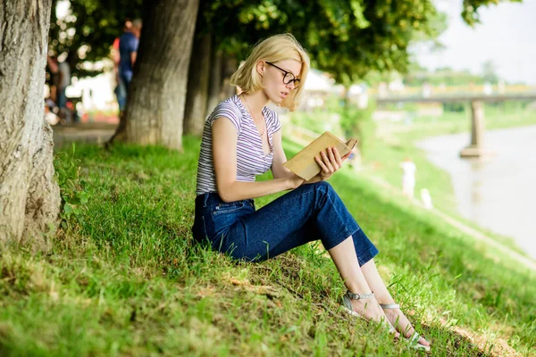 Riposo relax e hobby. Una donna che sogna una vacanza. Vacanze estive. Studente nerd intelligente sedersi su erba verde e leggere il libro. Letteratura per le vacanze estive. Ragazza rilassante sul lungofiume dopo la giornata di lavoro — Foto Stock