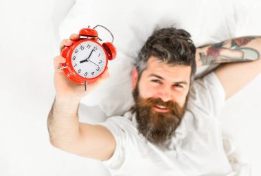 Yukarıdan bakınca, sakallı, esmer, seksi adam gülümsüyor.