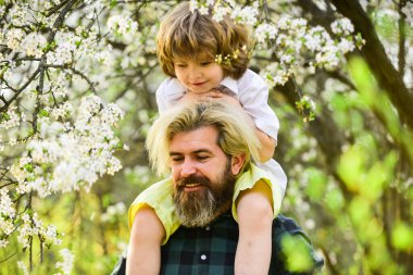 Baba ve oğul çiçek açan ağaçta. Bahar zamanı birlikte. Küçük çocuk babasıyla mutlu. Aile eğleniyor. Parkta çiçek açan ağaç. çocukluk ve ebeveynlik mutluluğu. Sevgi ve destek