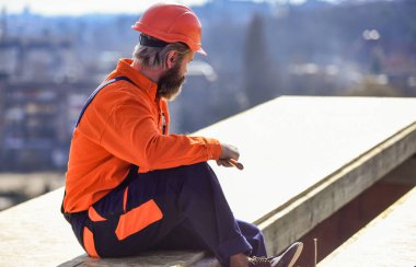 Çatının yalıtım yüzeyine kısmen üst üste binen malzeme katmanları yükle. Ana onarım çatısı. Düz çatı kurulumu. Çatı tamircisi. Çatıda adam var. Malzeme gereksinimleri