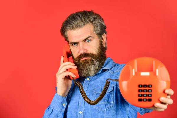 Maturo uomo barbuto parlare al telefono retrò. tecnologia vintage nella vita moderna. Un giovanotto che parla al telefono. Un hipster anziano che mostra un vecchio telefono. brutale ragazzo con telefono — Foto Stock