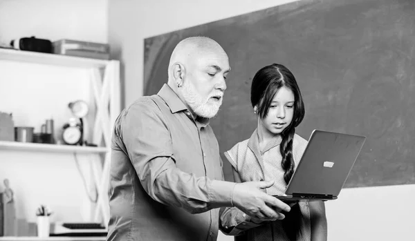 Pedagogo de la ciencia digital. Niña con tutor hombre estudio mantenga portátil. Lección en línea. Pedagogo amable. Pedagogo experimentado. De vuelta a la escuela. Enseñando a un niño. Profesor ayudar a colegiala —  Fotos de Stock