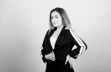 Zarif ve atletik parçaları karıştırıyorum. Spor kıyafetleri podyumlarda kural koyuyor. Mavi arka planda gülümseyen bir kadın. Voluminous kıvrımlı saç stili. Moda kıvrımlı saç stili. Spor şıklığı