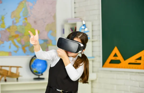 Headshot kills. Virtual classes. VR technology. schoolgirl using virtual reality helmet. Virtual reality headset. Teenager student girl in classroom. Play game. Explore cyber space. Digital world
