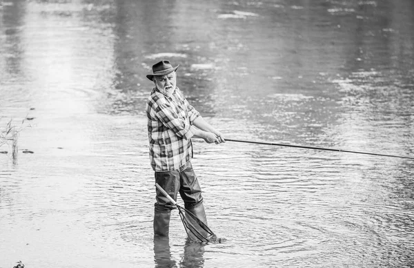 Pescatore in pensione. Tempo libero maschile. Pescatore con canna da pesca. Attività e hobby. Pesca d'acqua dolce lago stagno fiume. La felicità è bastone nella vostra mano. Uomo anziano che cattura pesce. Uomo maturo pesca — Foto Stock