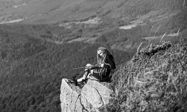 Concept d'objectif. Saison de chasse. Hunter montagnes paysage arrière-plan. Guerrier sexy. Femme attrayant cheveux longs joli visage tenir fusil pour la chasse. Amazon fille assis sur la falaise préparer pistolet pour la chasse — Photo