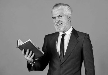 Olgun bir adam sakal ve saç boyadı. Kitap okuyorum. Notlarını kontrol et. Günlük program. Erkek profesyonel öğretmen. Berber dükkanından sonra. İşletme okulu eğitimi. Mutlu iş adamı defteri tutar.