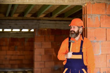 Yapı ve inşaat. Yetenekli mimar tamir ve onarım. Mühendis. Olgun sakallı adam çekiç kullanır. Bitmemiş bir binada inşaatçı. Kasklı profesyonel bir tamirci.