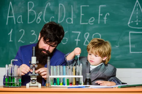 Mit dem Mikroskop im Labor. Zurück zur Schule. Student bei naturwissenschaftlichen Experimenten mit Mikroskop im Labor. Lehrer mit kleinem Jungen. Schullaborausstattung. Vater und Sohn in der Schule — Stockfoto