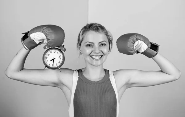 Es hora del entrenamiento de boxeo. guantes de boxeo mujer feliz. Chica boxeadora mantenga el despertador. energía de la mañana. lleno de poder. tiempo de actividad. Estableciendo la hora del reloj. Es hora de pelear. ganar el día —  Fotos de Stock