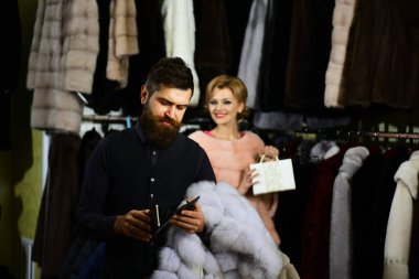 Sakallı müşteri ve kadın palto alıyor. Birbirine aşık çift