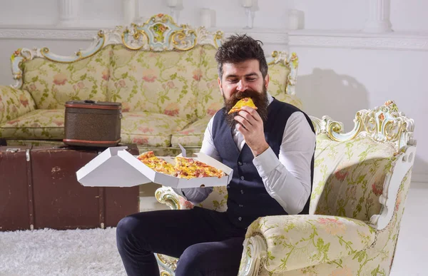 Sakallı ve bıyıklı bir adam lezzetli taze pizzayla dolu bir kutu tutuyor. Klasik giyinmiş maço aç, bir dilim peynirli pizza tutuyor, yiyor, tadını çıkarıyor, arka planda kalıyor. Afiyet olsun.. — Stok fotoğraf