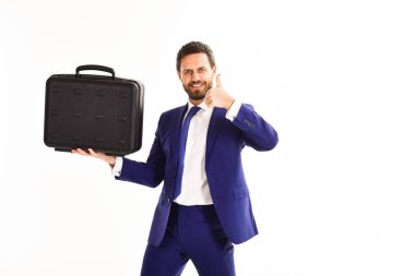 Adam elinde siyah bir çanta taşıyor. Takım elbiseli adam
