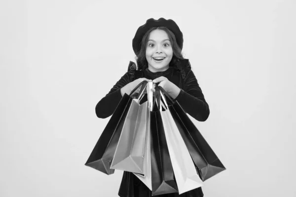 Internasjonal barnedag. Bursdag og julegaver. Et lite jentebarn med handleposer. stort salg på kjøpesenteret. God shopping på nettet. Tunge poser. Rolig og raskt – stockfoto